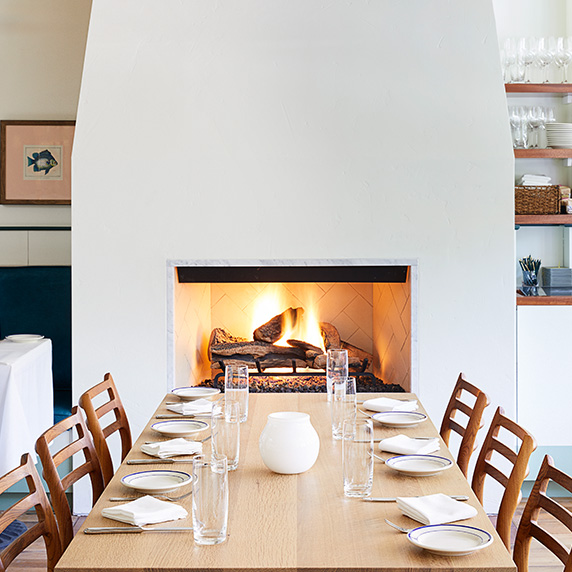Clarks Oyster Bar Aspen dining room with fireplace and table set for guests arriving